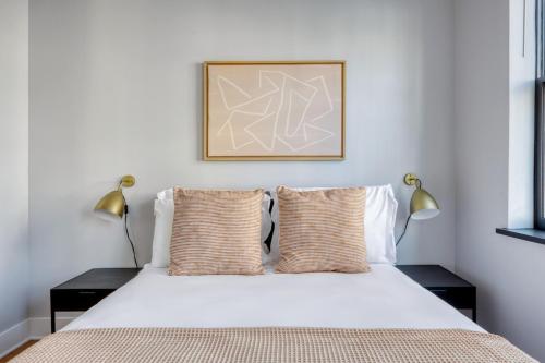 a bedroom with a white bed with two lamps at West Village 3br w wd nr Pier 46 NYC-1098 in New York