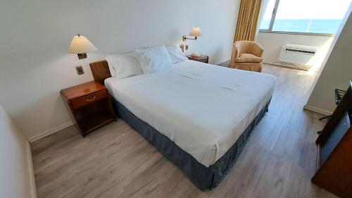 Un dormitorio con una gran cama blanca y una ventana en Hotel Diego De Almagro Costanera - Antofagasta, en Antofagasta