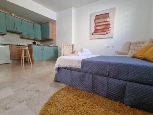 セビリアにあるDeluxe Apartment LA PLATAのベッドルーム(青いベッド1台付)、キッチン