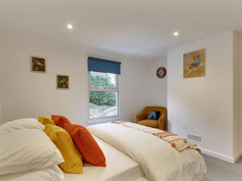 a white bedroom with a bed and a window at Pass the Keys Cosy Cottage Hawkhurst in Cranbrook