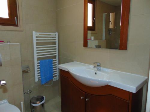 a bathroom with a sink and a mirror and a toilet at Ithaki Phinikoudes Apartments No. 106 in Larnaka