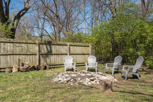 three chairs sitting around a fire pit in a yard at The Titan - Pet-friendly Bungalow in Nashville