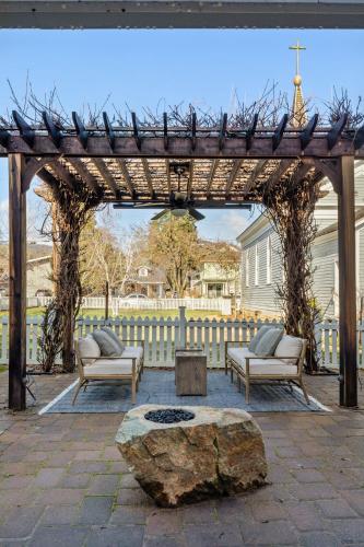 a wooden pergola with two chairs and a table and a rock at Magnolia Hotel in Jacksonville