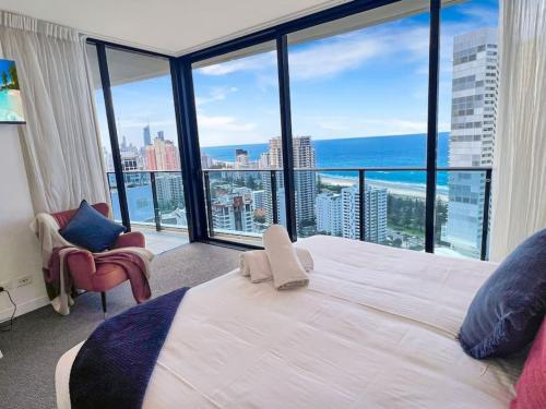 a bedroom with a large white bed and large windows at 29th floor Oracle Tower 2 stunning ocean and city views in Gold Coast