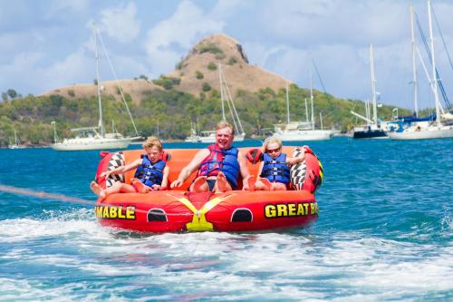 a man and two children on an inflatable boat in the water at Bay Gardens Beach Resort & Spa in Gros Islet