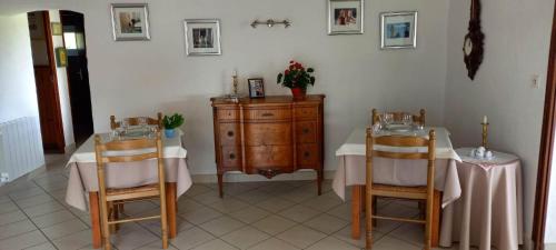 una sala da pranzo con due tavoli e un comò di Auberge Le Champêtre a Saint-Cierge-sous-le-Cheylard