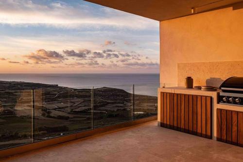 a kitchen with a view of the ocean at Lighthouse View Apartment in Żebbuġ