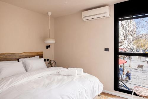 ein Schlafzimmer mit einem weißen Bett und einem Fenster in der Unterkunft 4room luxury apartment, Mamilla in Jerusalem