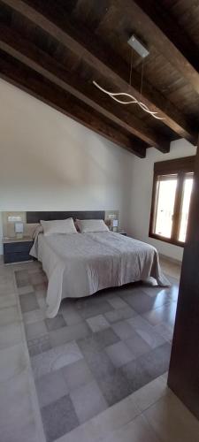 - une chambre avec un grand lit et une fenêtre dans l'établissement Casa Rural Raiztruf, à Cinctorres