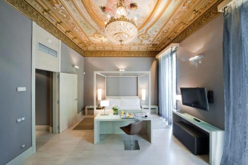 a room with a bed and a table and a ceiling at Hotel Actual in Barcelona