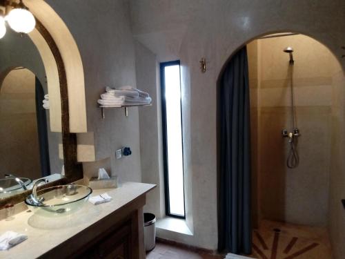 La salle de bains est pourvue d'un lavabo et d'une douche avec un miroir. dans l'établissement Villa Malaa'ika, à Marrakech