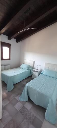 - une chambre avec 2 lits et une fenêtre dans l'établissement Casa Rural Raiztruf, à Cinctorres