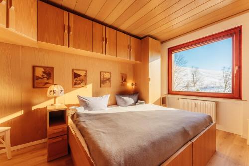 Schlafzimmer mit einem großen Bett und einem Fenster in der Unterkunft Bergschwalbe St. Andreasberg in Sankt Andreasberg