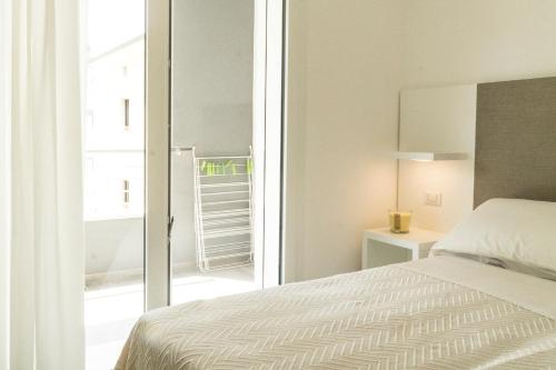 een witte slaapkamer met een bed en een balkon bij Fratino Pigro Residence in Alba Adriatica