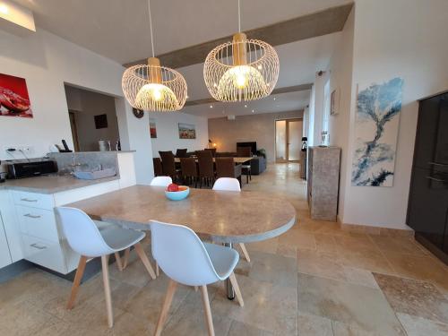 a kitchen and dining room with a table and chairs at Domaine Les Grenadiers de Saint Sat in Saint-Saturnin-lès-Apt
