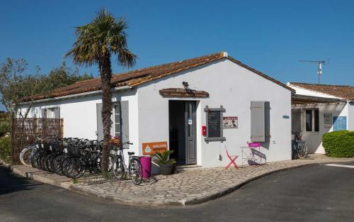 Biały budynek z rowerami zaparkowanymi przed nim w obiekcie Camping Les Perouses w mieście Saint-Clément-des-Baleines