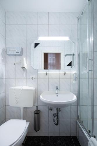 Un baño blanco con lavabo e inodoro. en Hotel BELLEVUE am Kurfürstendamm, en Berlín