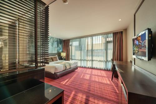 a bedroom with a bed and a large window at M2 de Bangkok Hotel in Bangkok