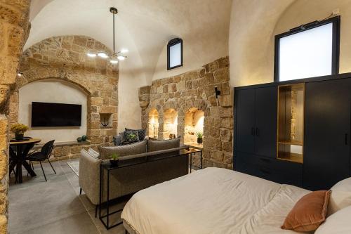 um quarto com uma cama e uma parede de pedra em Mirsa em Acre