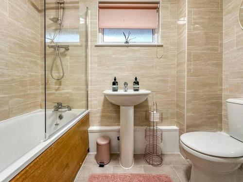 a bathroom with a sink and a toilet and a tub at Newly Refurbished 3 Bed House Near London o2 Arena in London