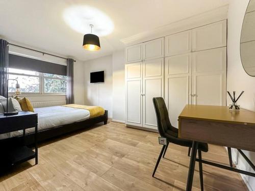 a bedroom with a bed and a desk and a desk at Newly Refurbished 3 Bed House Near London o2 Arena in London