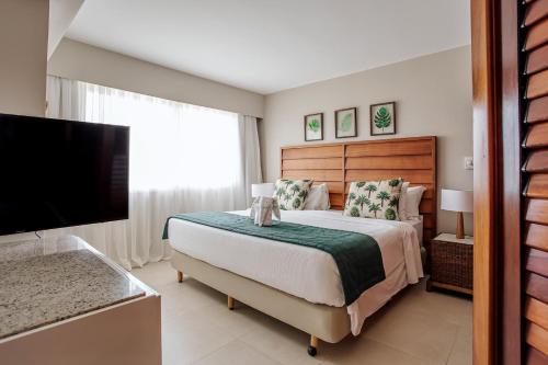 a bedroom with a bed and a flat screen tv at Sauipe Grand Premium Brisa - All Inclusive in Costa do Sauipe