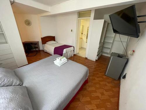 a hotel room with two beds and a flat screen tv at Zigal hotel in Antofagasta