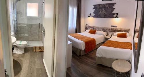 a hotel room with two beds and a bathroom at Hotel Bella Dolores in Lloret de Mar