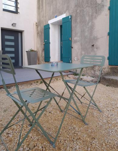 une table et deux chaises devant un bâtiment dans l'établissement le Cabanon perché, à Fournès