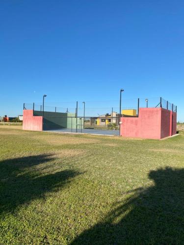 a field of grass with a fence and a basketball court at Chalet Premium en Villa Privada "Casa Bonita" in San Rafael