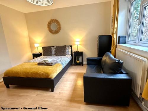 a bedroom with a bed and a couch and a window at Charming Flats with Fast WIFI on the Famous Abbey Road in London