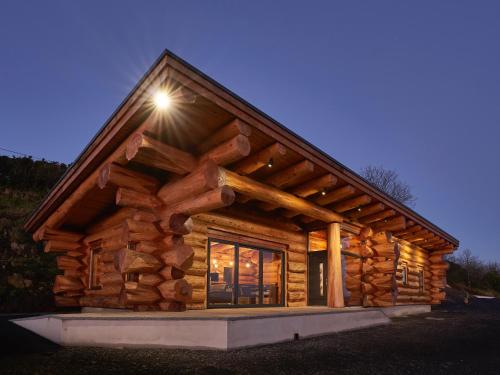 a log cabin with a light on the roof at Aurora North Coast in Bushmills