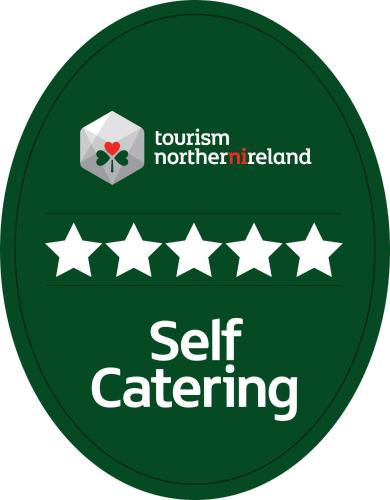 a green sign with the words self catering at Aurora North Coast in Bushmills