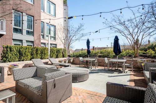 a patio with chairs and tables and umbrellas at Kasa Alexandria Washington in Alexandria