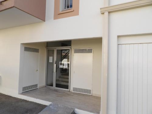 un accès à un bâtiment avec deux portes de garage dans l'établissement Cosy studio au bord de la plage, à Gruissan