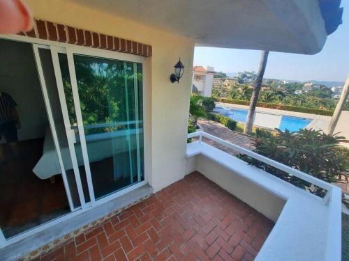 a balcony of a house with a view of a swimming pool at Villa del Palmar departemento in Manzanillo
