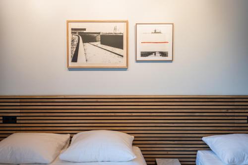 a bedroom with two beds and two pictures on the wall at Weber Hotel in Amsterdam
