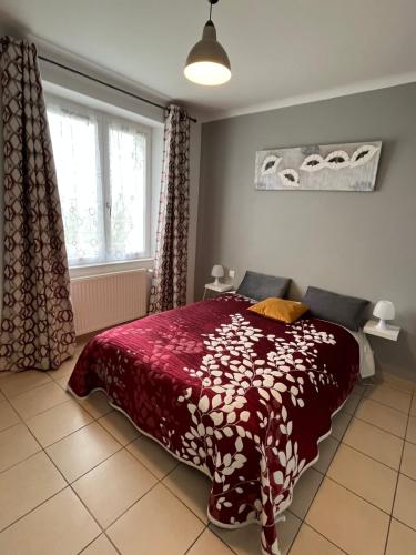 um quarto com uma cama com um edredão vermelho e uma janela em Domaine de la moriniere em Commequiers
