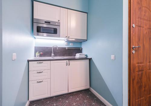 a kitchen with a sink and a microwave at Station Self Check-in Apartments - Lollo Stay in Vilnius