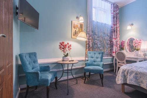 a room with two chairs and a table and a bed at Station Self Check-in Apartments - Lollo Stay in Vilnius