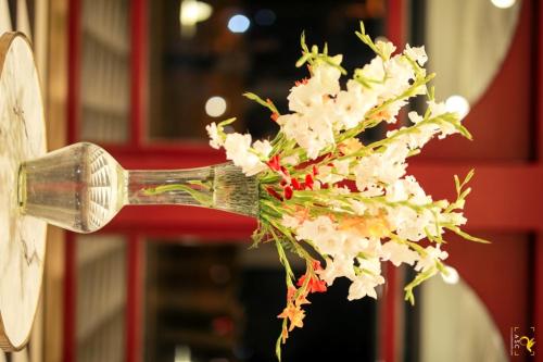 a bouquet of white flowers in a wooden spoon at Clarks Inn Suites Raipur in Raipur