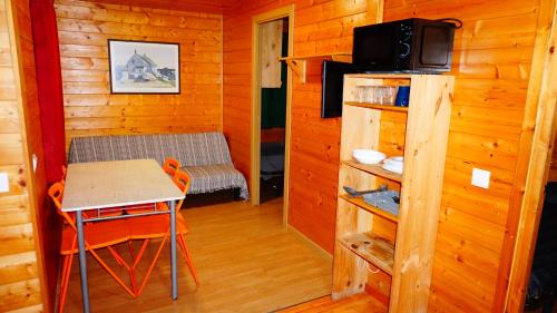 Habitación pequeña con mesa y TV en una cabina. en Bungalows Park Albufera en El Saler