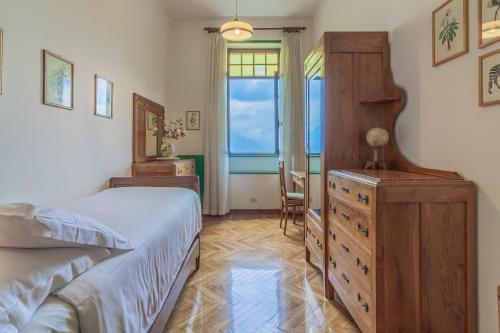 a bedroom with a bed and a dresser and a window at Family Villa with Stunning Lake View by Wonderful Italy in Civenna