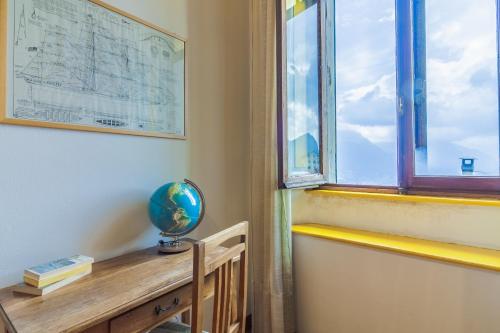 a room with a window and a desk with a globe on it at Family Villa with Stunning Lake View by Wonderful Italy in Civenna