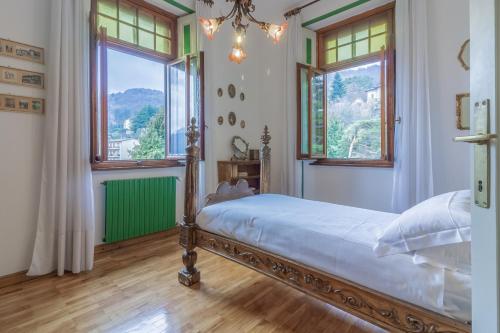 a bedroom with a bed and two windows at Family Villa with Stunning Lake View by Wonderful Italy in Civenna
