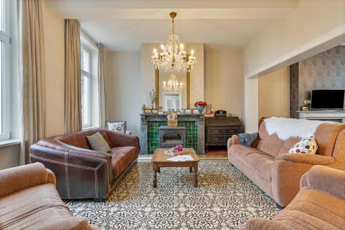 a living room with two couches and a fireplace at Oud Brouwershof in Alveringem
