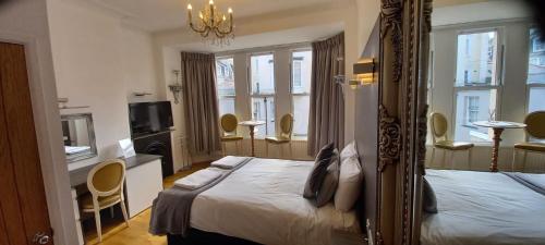 a hotel room with two beds and a mirror at Grosvenor House in Ilfracombe