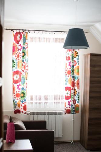 a living room with a window with curtains and a lamp at Apartamenty Gorczańskie in Rabka