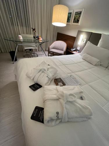 ein Hotelzimmer mit einem Bett mit Handtüchern darauf in der Unterkunft Bugan Recife Boa Viagem Hotel - by Atlantica in Recife