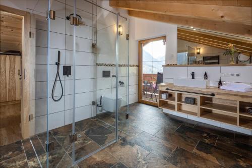 ビショフスヴィーゼンにあるBergbauernhof Schoberlehenのバスルーム(シャワー、洗面台、トイレ付)